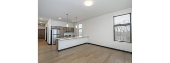 A kitchen with a refrigerator, sink, and stove top oven.