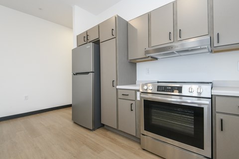 A kitchen with a stainless steel refrigerator, oven, and cabinets.