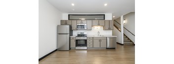 A modern kitchen with stainless steel appliances and wooden floors.