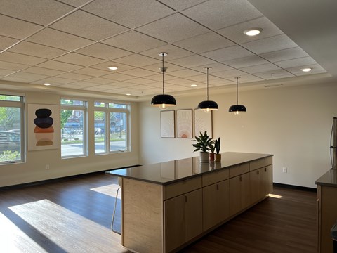 A reception area with a counter and three hanging lights.