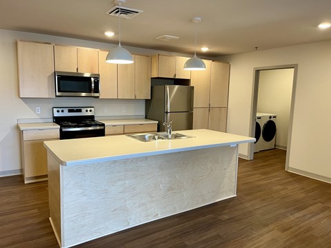 A kitchen with a white counter and wooden cabinets.