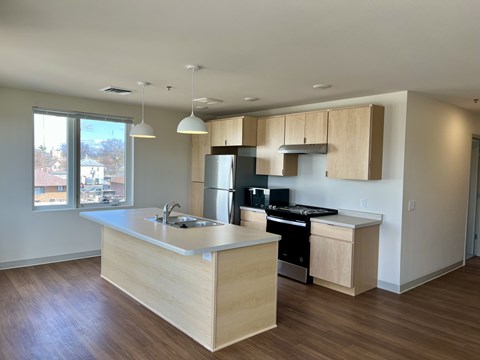 A kitchen with wooden cabinets and a stainless steel refrigerator.