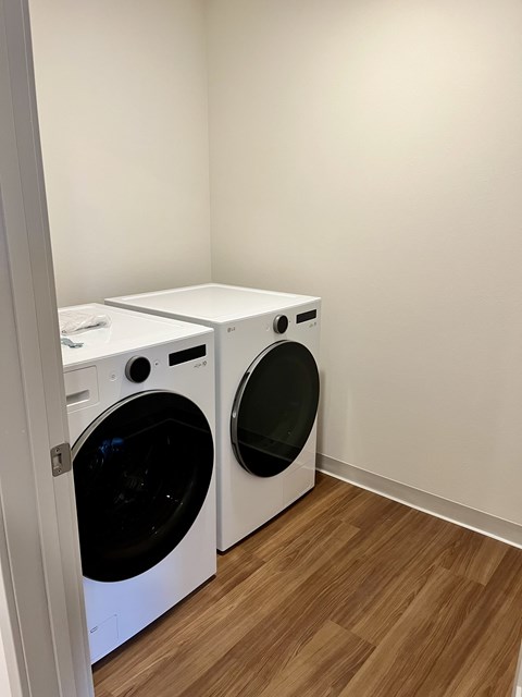 Two white front loading washing machines in a laundry room.