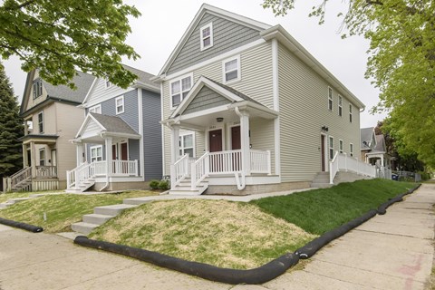A two-story house with a front porch and a front yard.