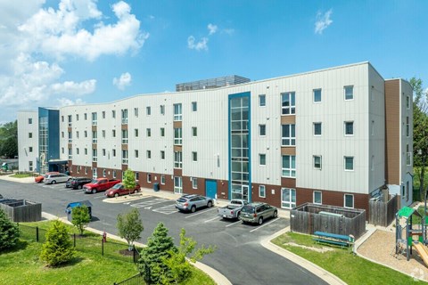 A large white building with a parking lot in front.