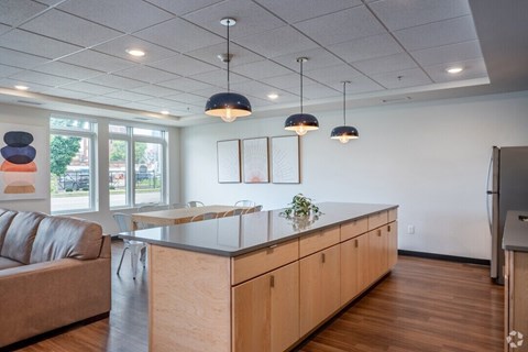 A modern kitchen with a wooden island and pendant lights.