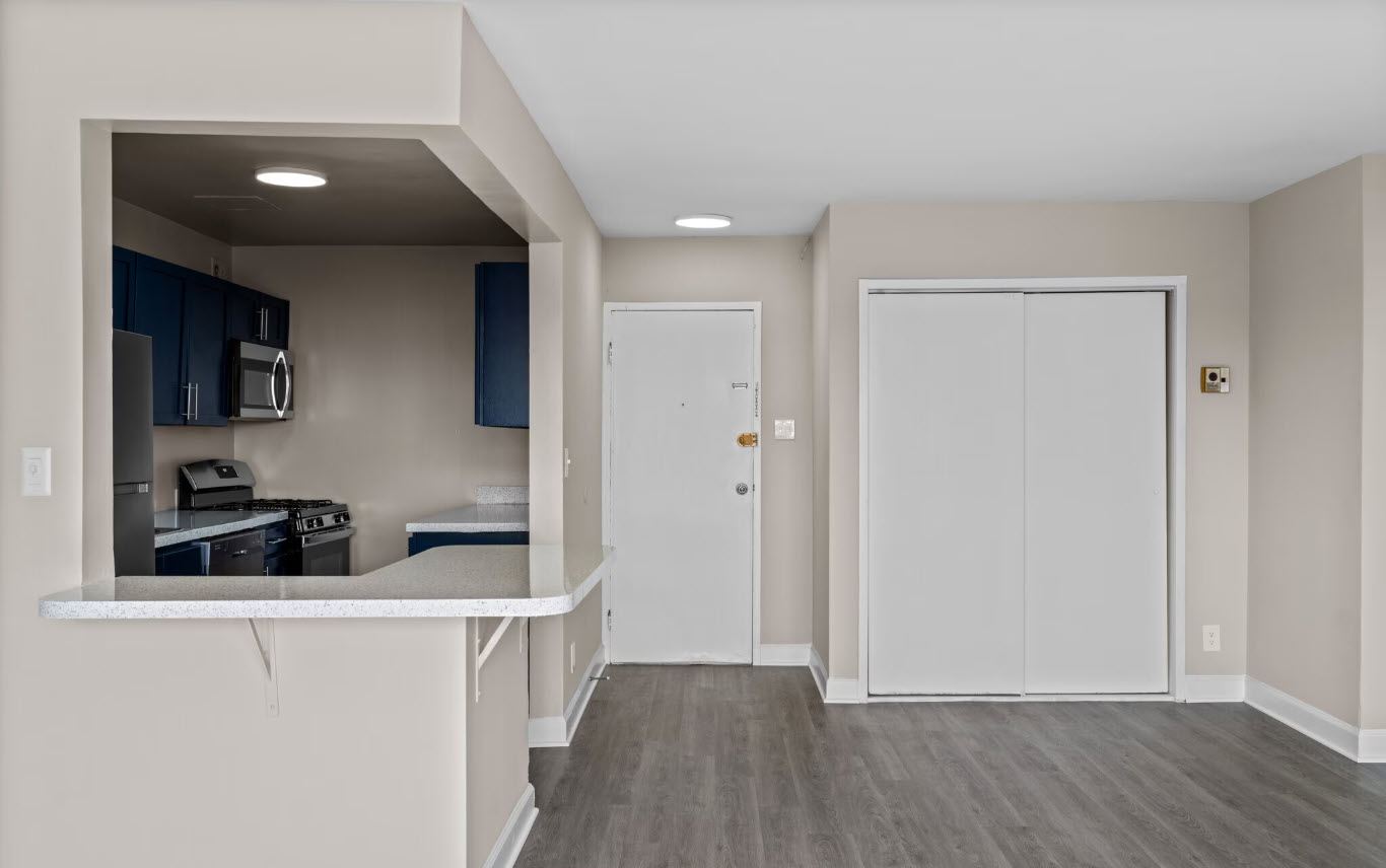A kitchen area with a white counter and cabinets.
