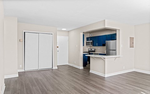 A kitchen area with a refrigerator, microwave, and cabinets.
