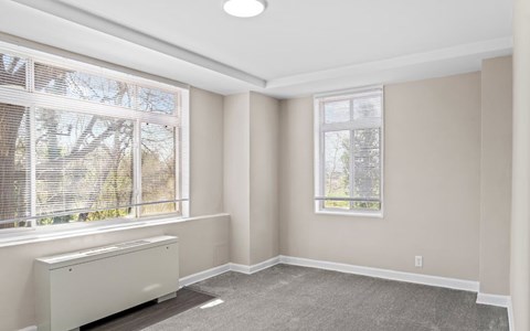 A room with a window and a radiator on the floor.