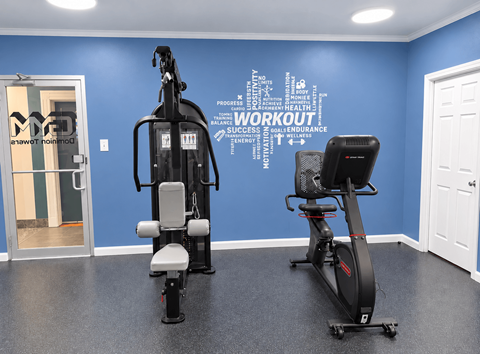 A gym room with a blue wall and a word cloud that says "workout".
