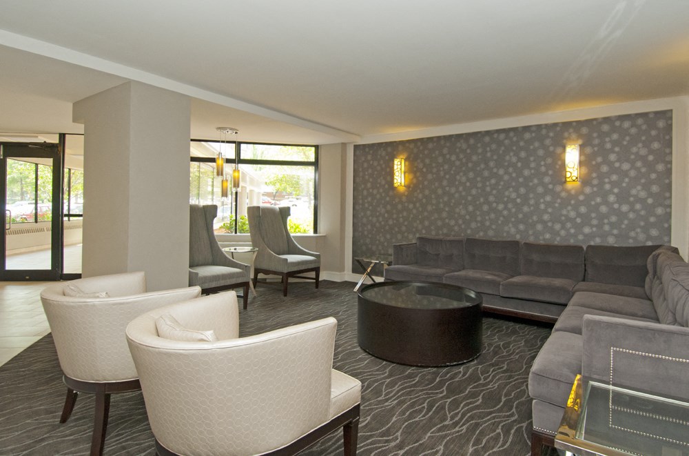 A living room with a grey couch and white armchairs.