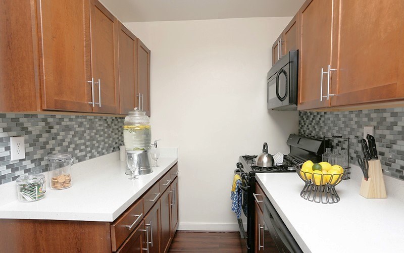 A kitchen with wooden cabinets and a white counter top at Dominion Towers Apartments, Arlington