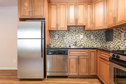 A kitchen with wooden cabinets and a stainless steel refrigerator at Potomac Ridge Apartments, Woodbridge, VA, 22191