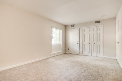 A room with a carpeted floor and two doors at Potomac Ridge Apartments, Woodbridge, VA, 22191