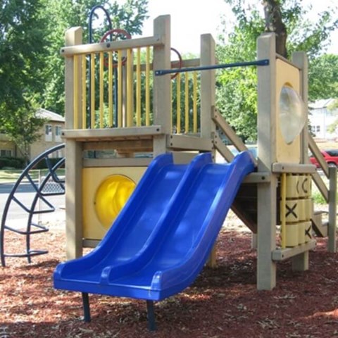 A blue slide is attached to a wooden play structure at Potomac Ridge Apartments, Woodbridge, 22191