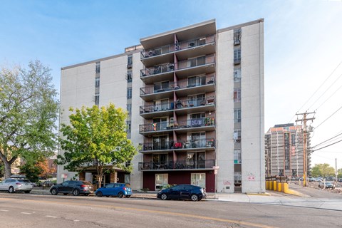 A tall apartment building with balconies on the side is in the foreground.