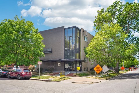 A building with a sign that says "Courtyard" is surrounded by trees and has a parking lot in front.