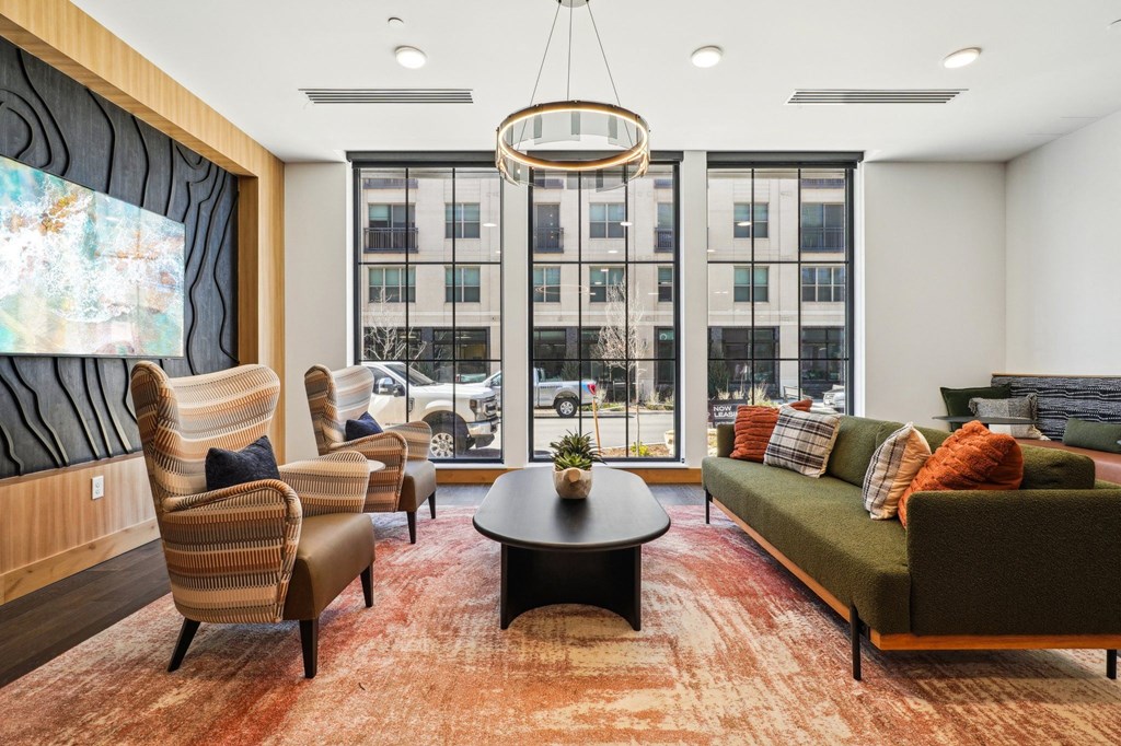 A living room with a large window and a view of the city.