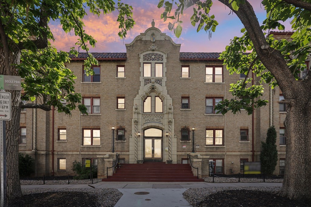 A large, historic building with a central arched entrance and a clock tower.