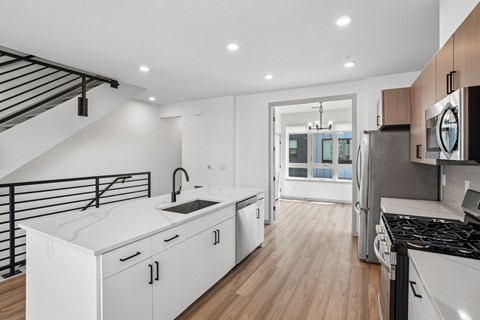 A modern kitchen with white cabinets and a black stove top oven.