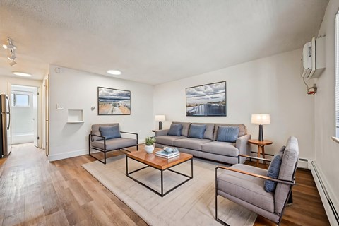 A living room with a grey couch, a black chair, and a coffee table.