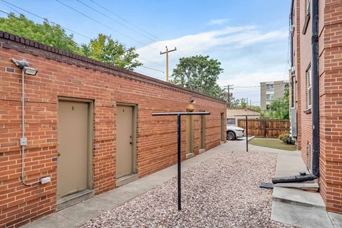 A long alley with brick walls and a gravel path.