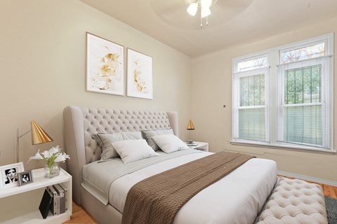 a bedroom with a large bed and two windows