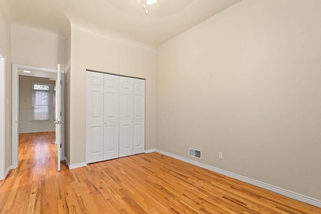 an empty living room with wood floors and a white door