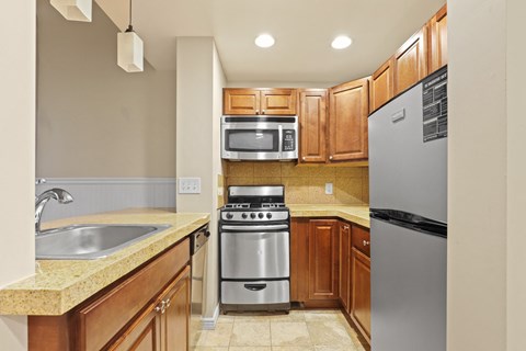 a kitchen with wooden cabinets and stainless steel appliances