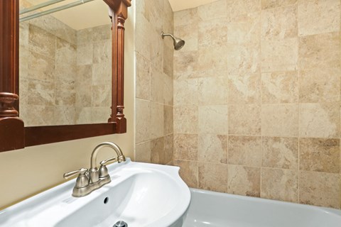 a bathroom with a sink and a tub and a mirror