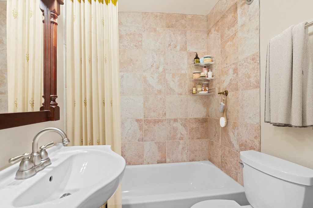 a small bathroom with a sink toilet and shower