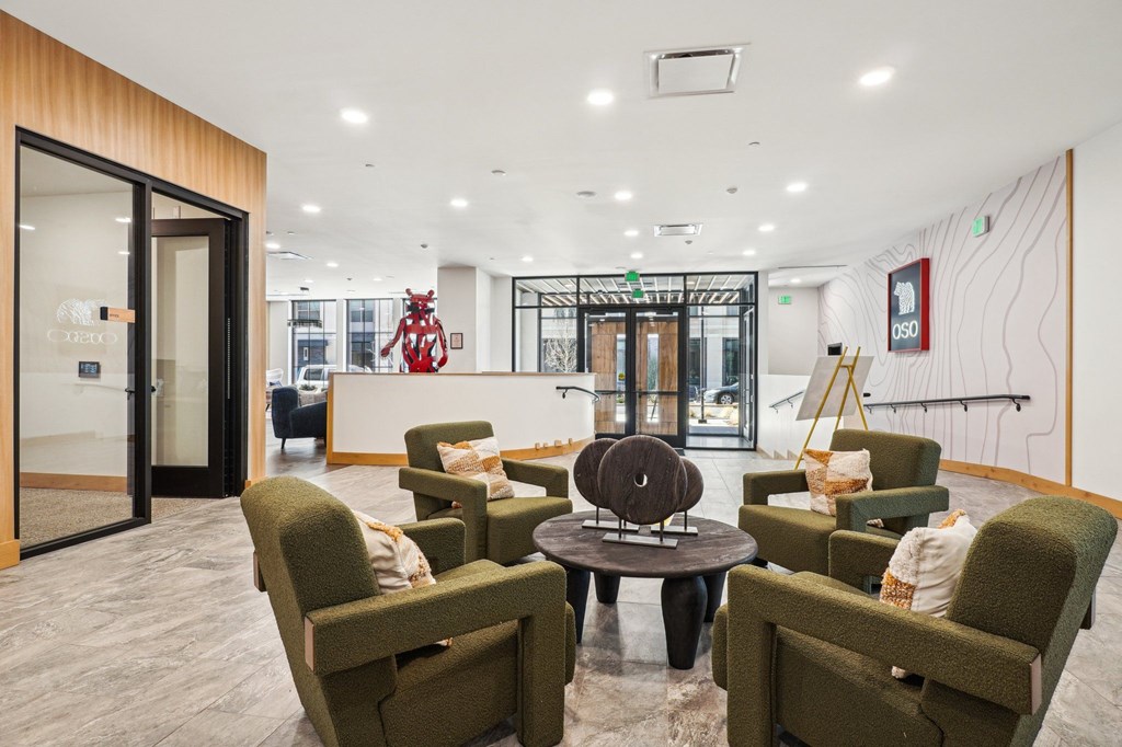 A waiting area with green chairs and a wooden table.