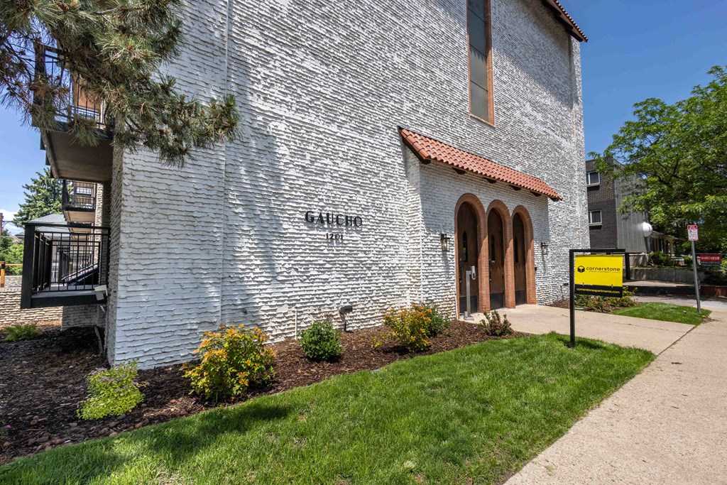 a white brick building with a yellow sign in front of it