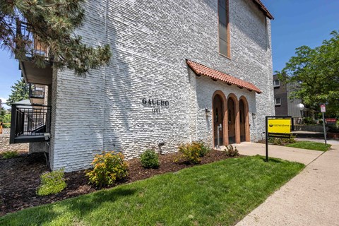 a white brick building with a yellow sign in front of it