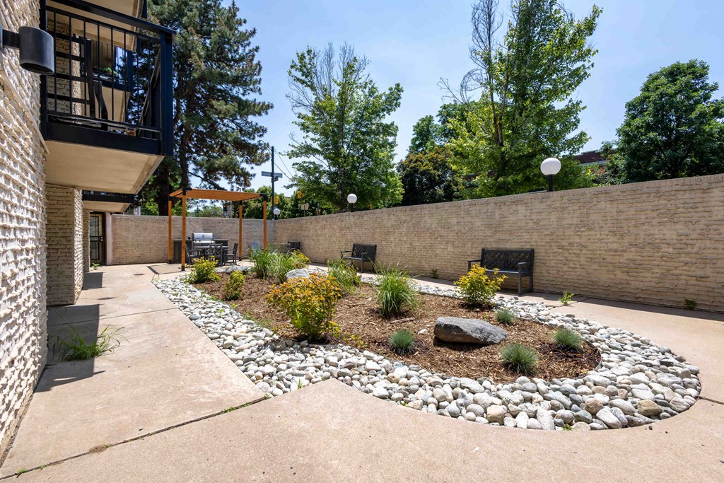 a courtyard with a rock garden and a brick wall