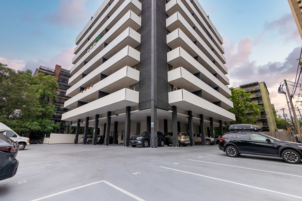 a parking lot in front of a building with cars parked in front