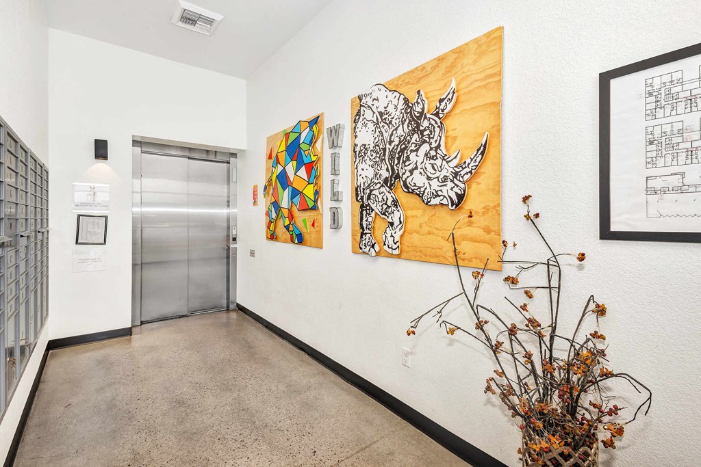 a hallway with artwork on the wall and a metal door