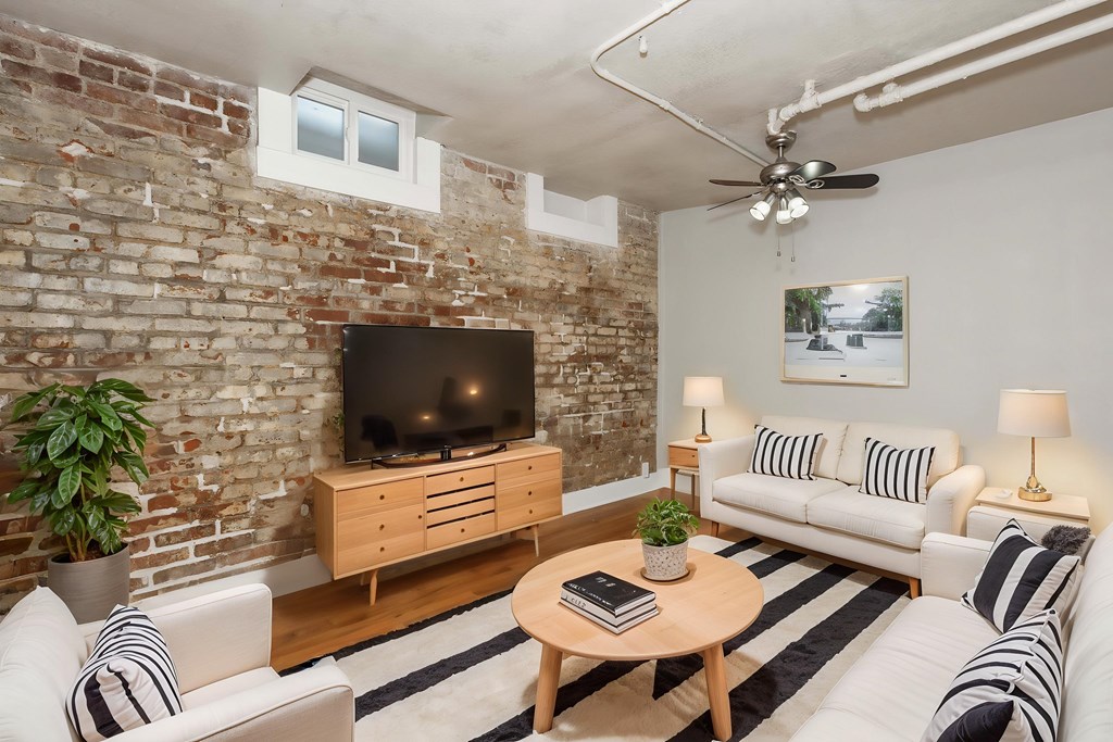 A living room with a brick wall and a television.