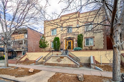 A brick building with a tree in front of it.