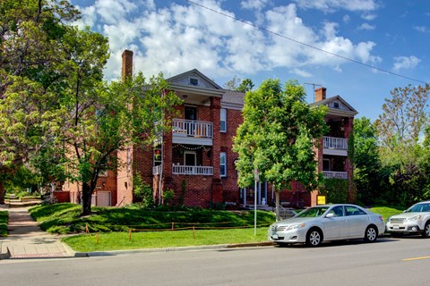 1236 E 12th Apartments in Denver, CO a large brick apartment building with a car parked in front of it