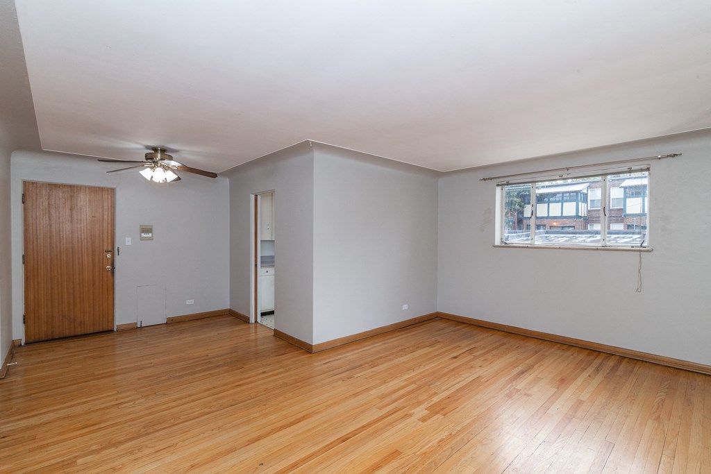 A room with wooden floors and a ceiling fan.