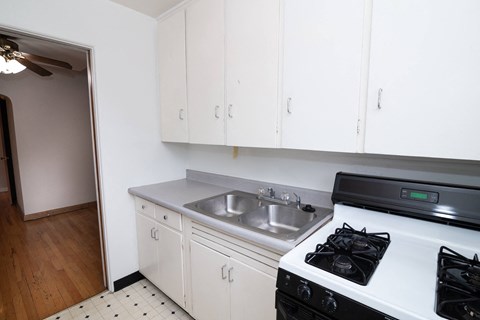 A kitchen with white cabinets and a black stove top oven.