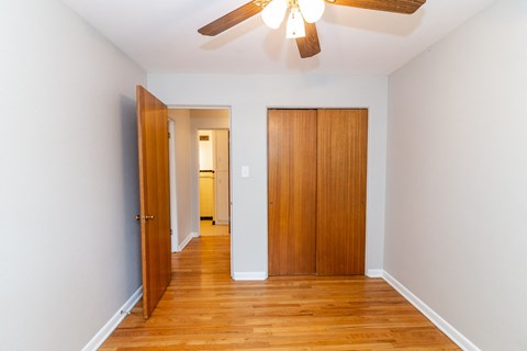 A room with a ceiling fan and two wooden doors.