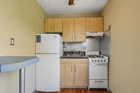 A small kitchen with a white refrigerator and a white stove top oven.