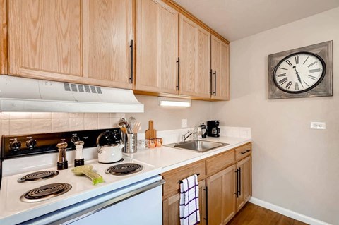 a kitchen with a stove and a clock on the wall