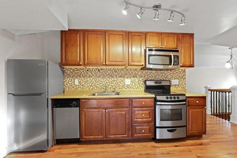 a kitchen with stainless steel appliances and wooden cabinets