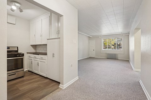 A kitchen with white cabinets and a stove top oven.