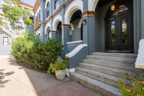 the front of a blue house with stairs and a door