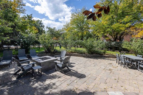 a patio with a table and chairs and trees
