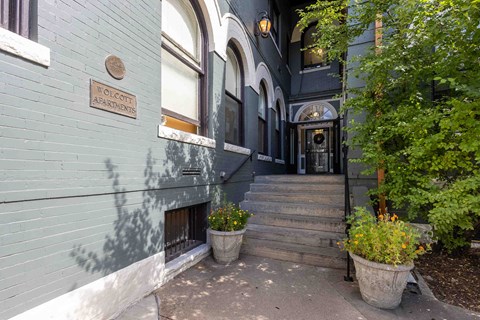the entrance to a building with stairs and plants